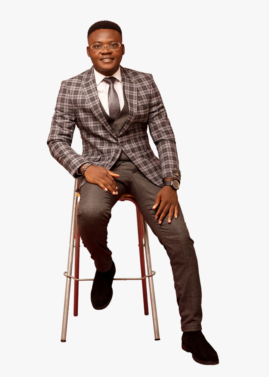 Chinedu Okeke seated on a studio stool, full-length portrait